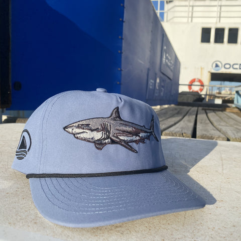 Dusty blue hat with shark graphic on front and Ocearch logo on side