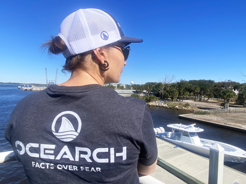 Woman overlooking water wearing heather midnight navy Stacked Back Logo Tee