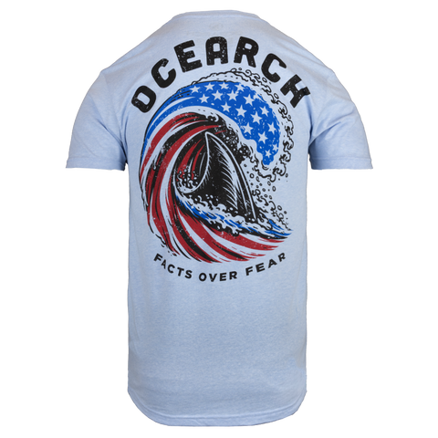Light blue tee with shark fin swimming in wave stylized as american flag with text "OCEARCH FACTS OVER FEAR"