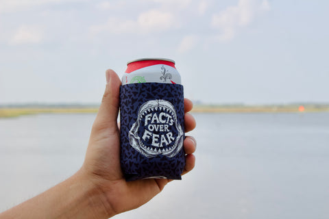 Hand holding OCEARCH 12 OZ Can Cooler with drink