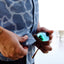 man wiping glasses on light blue Ocearch camo shirt