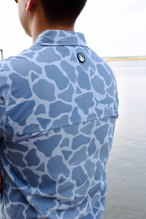rear view of man in light blue Ocearch camo shirt showing ocearch logo on back