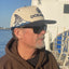 Man wearing natural / navy hat with "OCEARCH" logo on front and shark fin on side