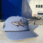Dusty blue hat with shark graphic on front and Ocearch logo on side