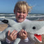 Child holding ocearch shark Plushie saying "Now we have this super soft plushie that everyone can learn and play with at home"